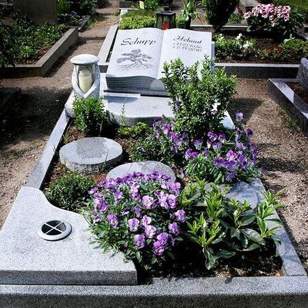 Grabmal mit kleinem Beet und Buchfigur